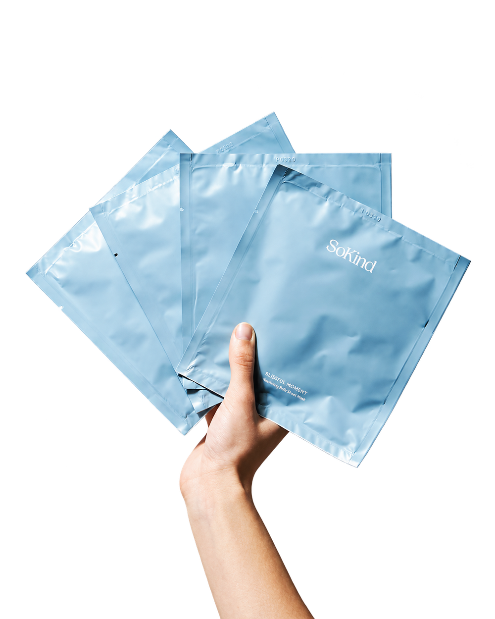 sokind-blissful-moment-belly-sheet-masks-hand-held.webp Hand holding four blue SoKind Blissful Moment nourishing belly sheet mask sachets